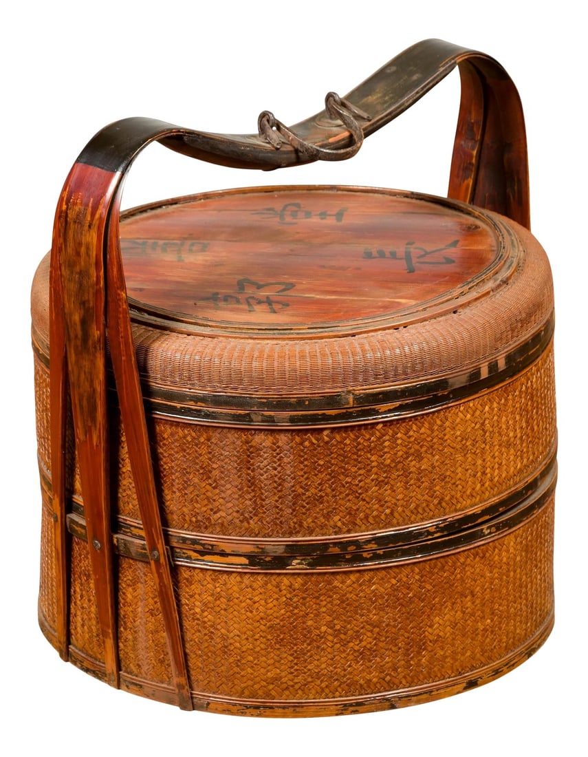 Antique Chinese Rattan Tiered Lunch Box with Carved Handle and Calligraphy: An antique Chinese rattan two-tiered nested lunch box from the early 20th century, with calligraphy and carved handle. Born in China during the early years of the 20th century, this lunch basket