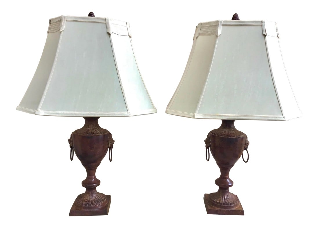Neoclassic Metal Lion Handle Urn Lamp: Faux finished neoclassic design metal lamps with lion heads with rings on each side. Both are in working order. Included are the custom corner pleated lamp shades. Priced as a pair. Condition: Alterat