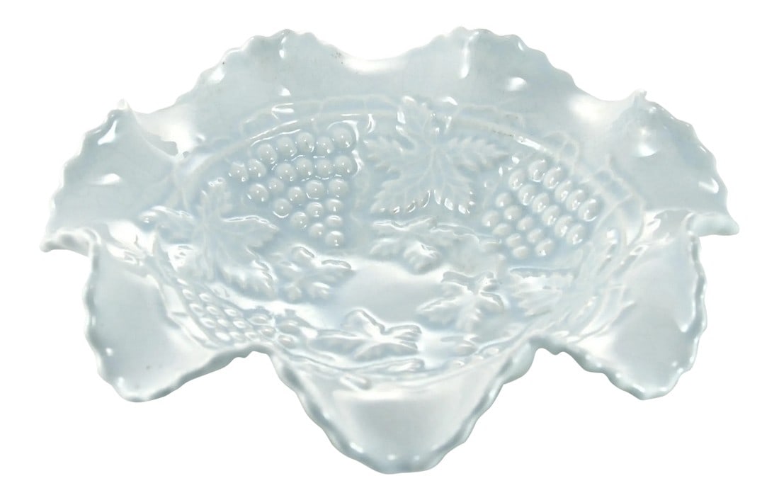 Ice Blue & White Grape Motif Bowl: Vintage ruffle rim creamy white bowl with by an ice blue over-glaze highlighting a raised majolica style grape leaf design. No maker's mark. Light wear and crazing. Condition: Alterations: Original