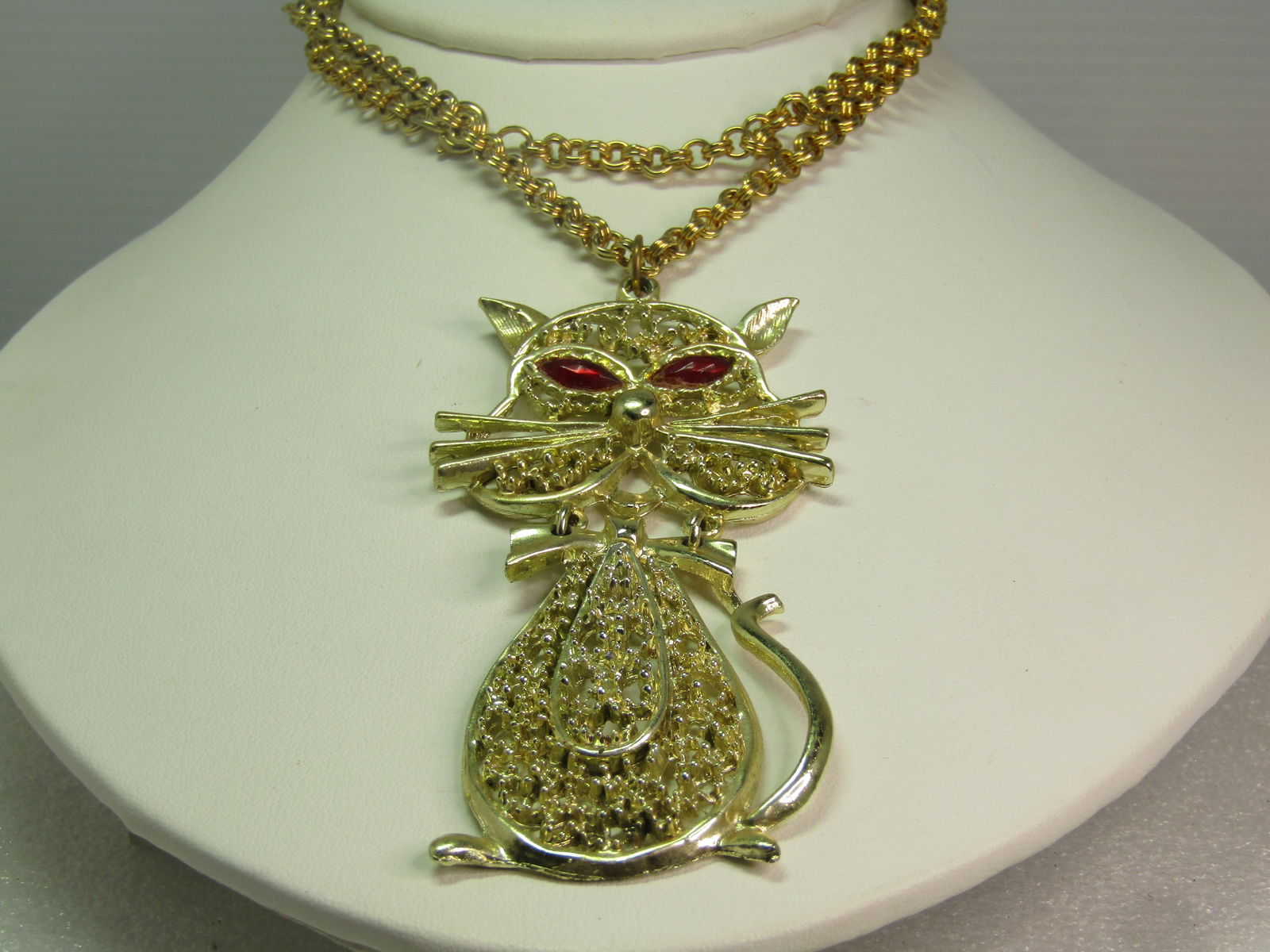 Vintage Tall Cat Necklace, Rhinestone Eyes, 24" Gold Tone, 1960's: Vintage Tall Cat Necklace, Rhinestone Eyes, 24" Gold Tone, 1960's. This kitty in is two-pieces - the head has two rings that the body swings from, articulated with tail comping up on the side. Filigre