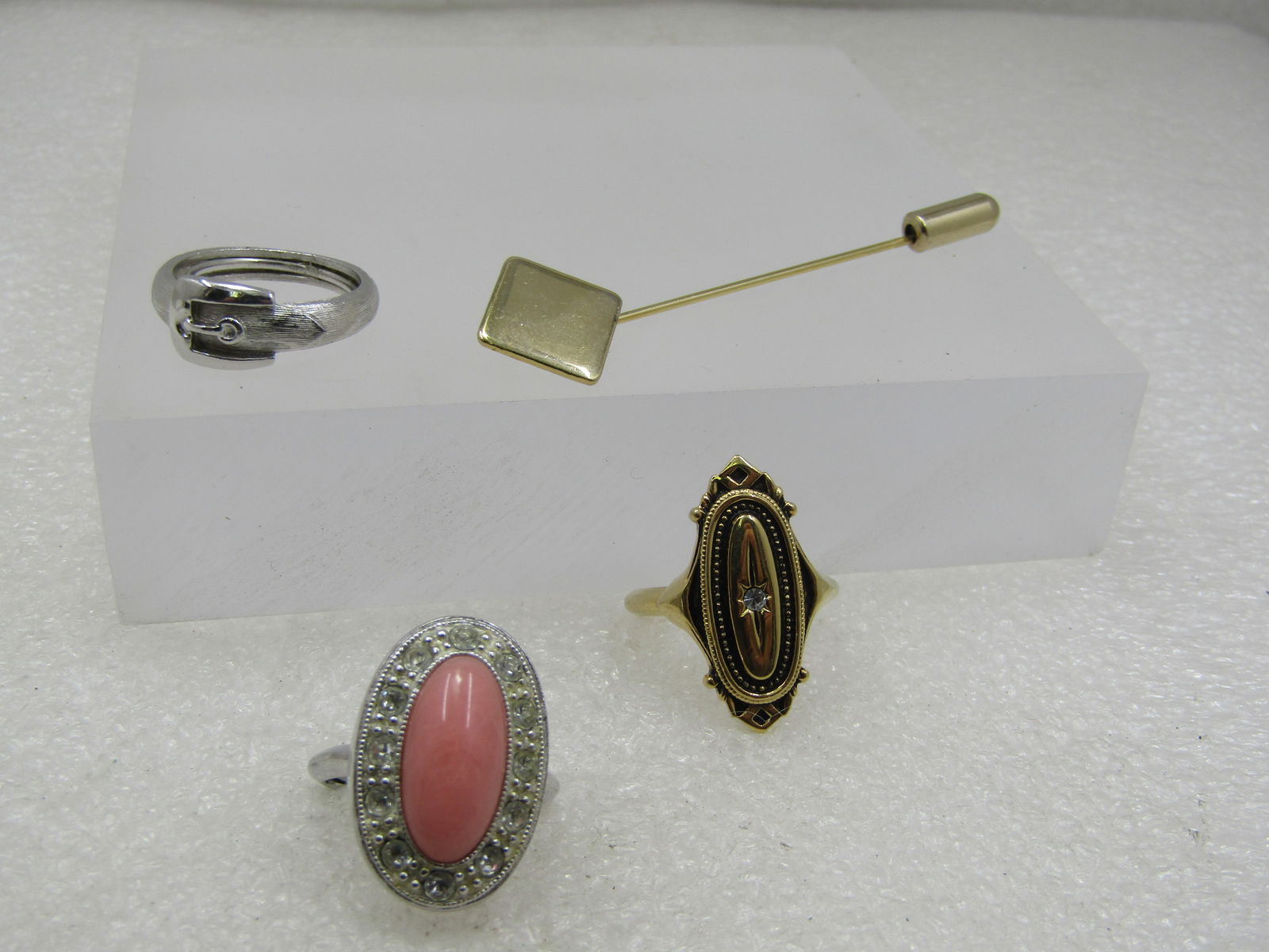 Vintage Avon 3 Ring , 1 Stick Pin Lot, Adjustable, 1970's-1980's: Vintage Avon 3 Ring , 1 Stick Pin Lot, Adjustable, 1970's-1980's. Silver tone belt ring in smooth and textured finish, adjustable; a victorian themed adjustable ring, gold tone; and a faux pink coral