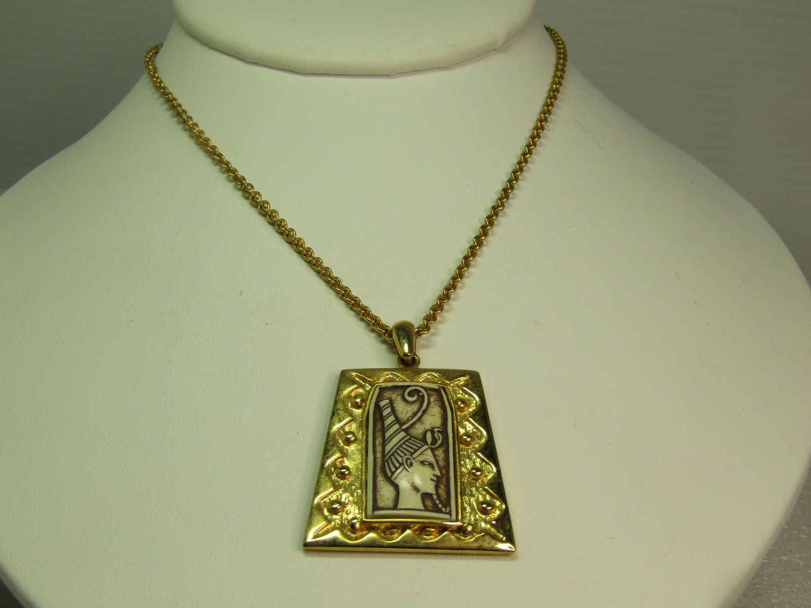 Vintage Egyptian Faux Carved Necklace, 18", Signed Celebrity, 1960's: Vintage Egyptian Faux Carved Necklace, 18", Signed Celebrity, 1960's. Gold tone with a pendant has has a decorative frame around a raised bezel-set faux carbed Egyptian figural center. The pendant has