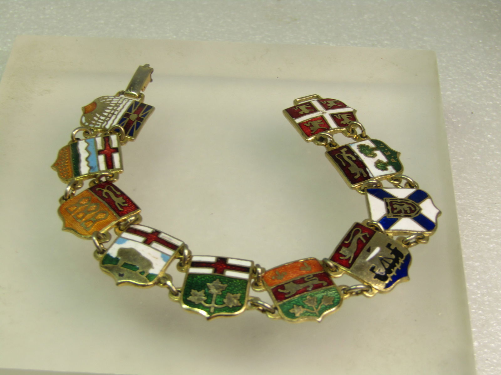 Vintage Enameled Flags of Canada Bracelet, 7.25", 1960's-1980's: Vintage Enameled Flags of Canada Bracelet, 7.25", 1960's-1980's is the approximate era for this bracelet. This has the flags of the provinces of Canada and the province is stamped on the back. The