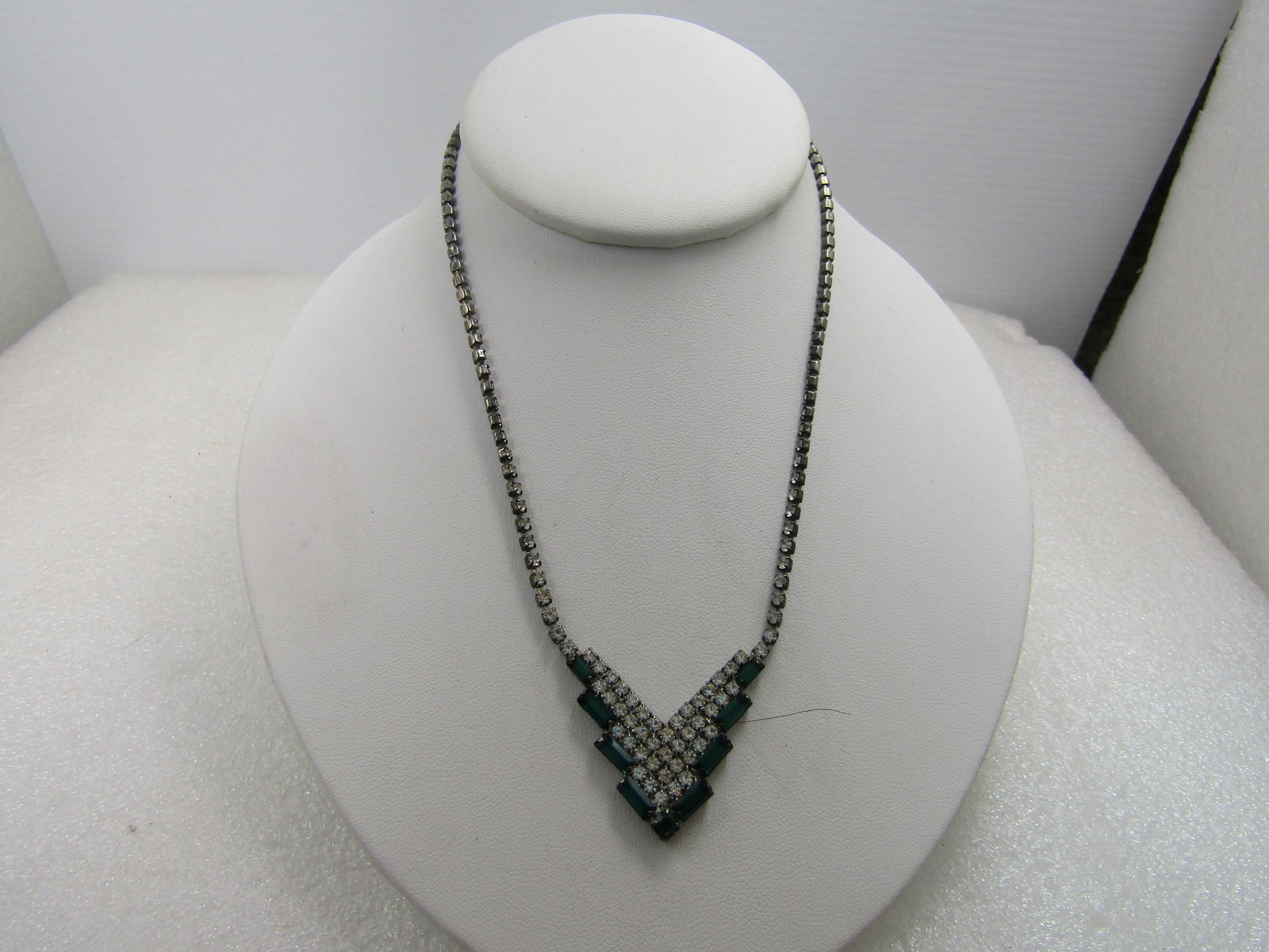 Vintage Clear and Emerald Green Rhinestone Necklace, V Drop, 1980's, 15.75": Vintage Clear and Emerald Green Rhinestone Necklace, V Drop, 1980's, 15.75". The necklace is round clear glass stones set in closed back settings and it is appx. 2.5mm wide. The drop is a v with four