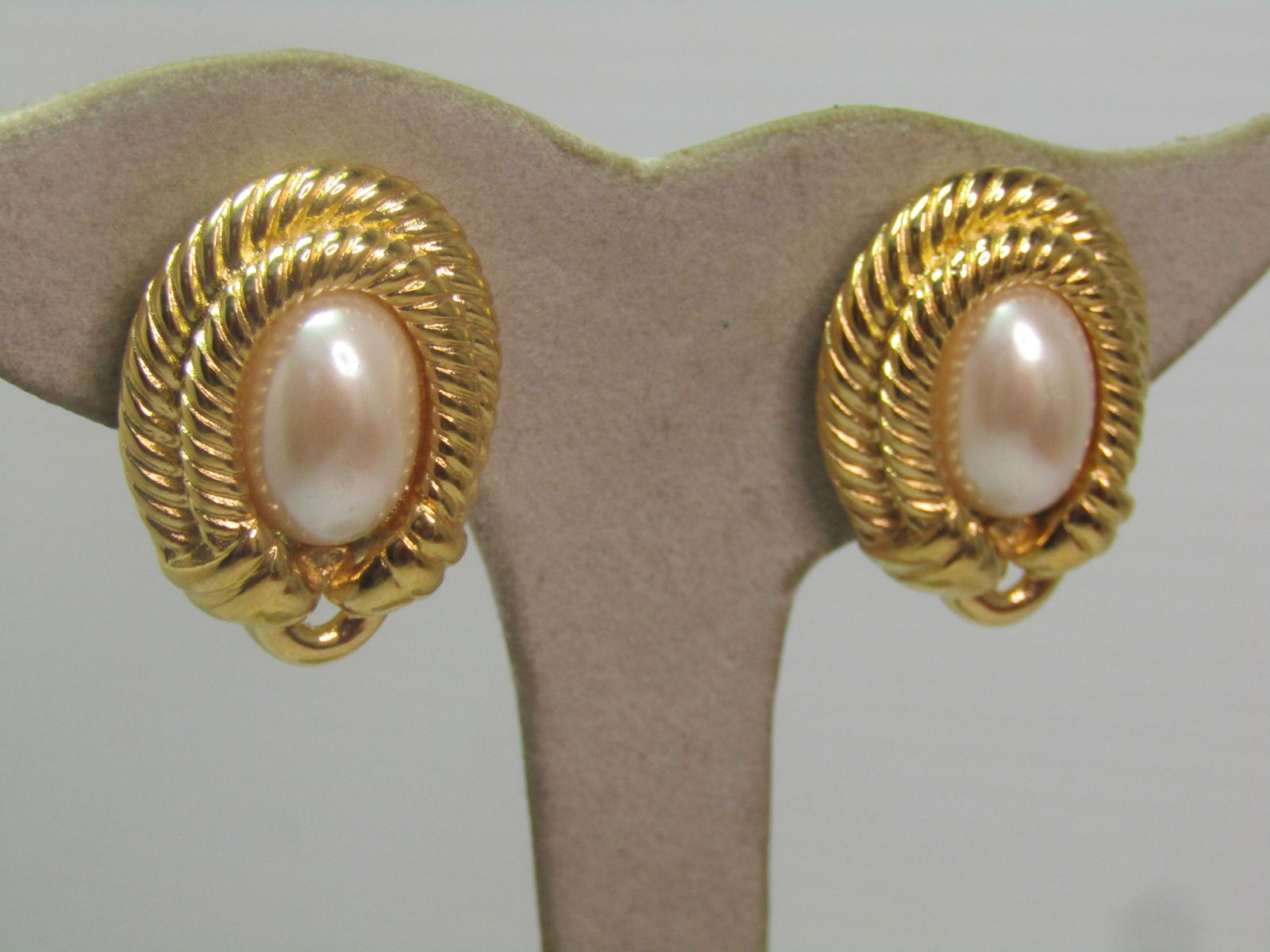 Vintage Givenchy Faux Pearl Earrings, Clip, On Card, 1980's-1990's: Vintage Givenchy Faux Pearl Earrings, Clip, On Card, 1980's-1990's. Gold tone oval with a double tiered rope accent frame arund most of itwith a buckle like accent at the base. They are appx. 1" tall