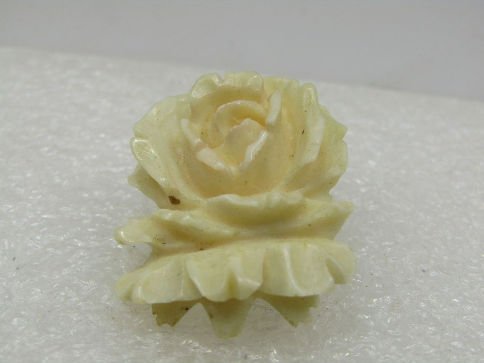Vintage White Carved Floral Brooch, C-Clasp, 1920's-1930's: Vintage White Carved Floral Brooch, C-Clasp, 1920's-1930's. This looks like a rose with curved back leaves. It is appx. 1" talla nd 3/4" wide with c-clasp. It is earlier 1900's and is believed to be p