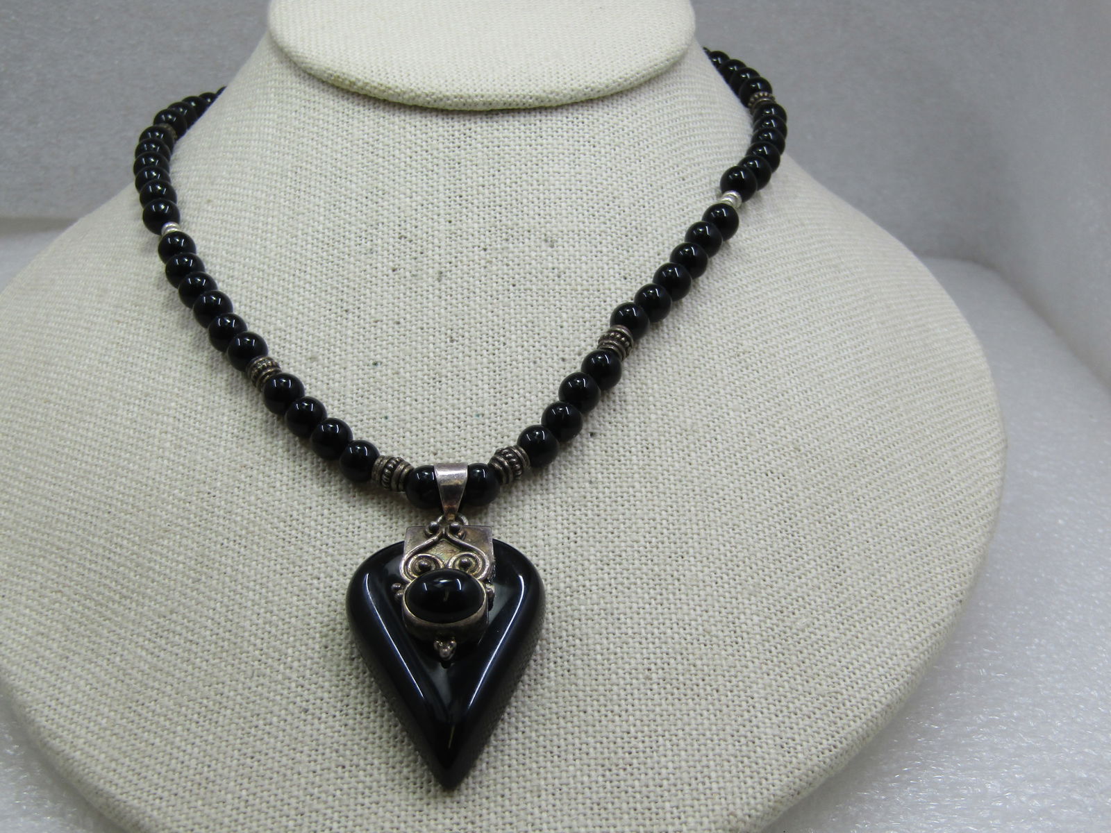 Vintage Sterling & Onyx Bali to Southwestern Necklace, Toggle, 17": Vintage Sterling & Onyx Bali to Southwestern Necklace, Toggle, 17". It has an upsidedown teardrop shaped onyx pendant with silver scrolled work in a Bali to Southwestern Stle and an oval bezel-set ony