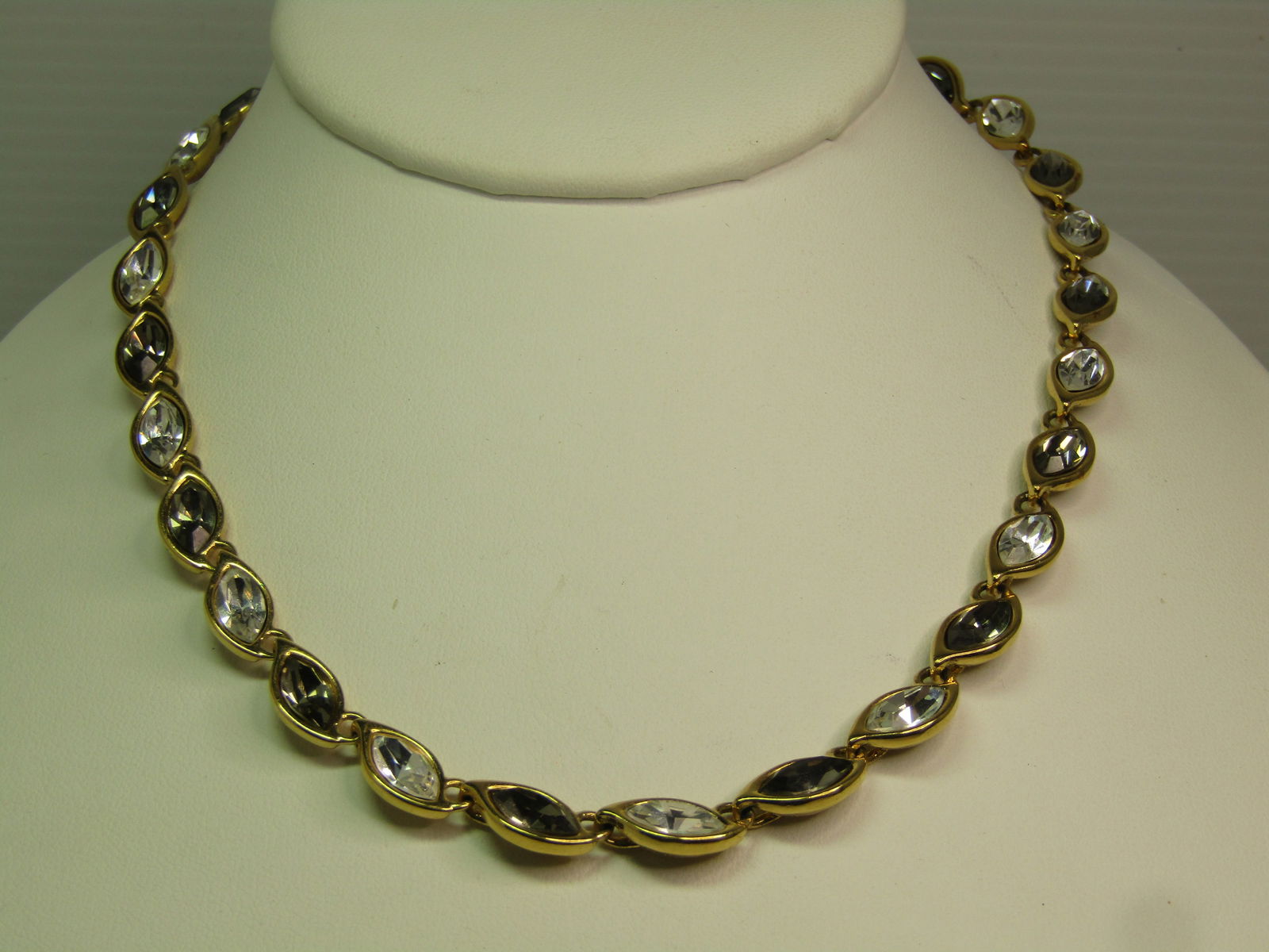 Vintage Monet Clear & Smoky Rhinestone Necklace, 17", 1970's-1980's: Vintage Monet Clear & Smoky Rhinestone Necklace, 17", 1970's-1980's. This has a hook clasp where it is signed Monet with a dangling clear marquise glass rhinestone that is appx. 9mm by 6mm and set in