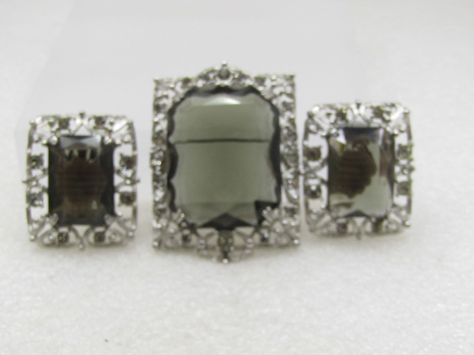Vintage Smoky Rhinestone Brooch & Earrings, Sarah Coventry. 1960’s.: Vintage Smoky Rhinestone Brooch/Pendant & Earrings, Sarah Coventry. 1960’s. Ornate silver tone metal securely set with emerald cut smoky topaz glass stone and accented with smoky topaz rhinestones.