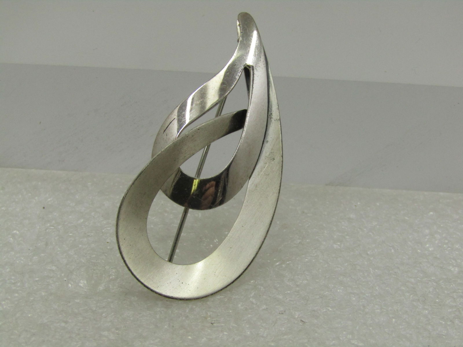 Vintage Sterling Beau Sterling Double Teardrop Brooch, 2.25", 1960's: Vintage Sterling Beau Sterling Double Teardrop Brooch, 2.25" and nearly 1" wide, 1960's. this looks like two intertwined droplets or a flame tip. Satin and smooth finish. Signed Beau Sterling and