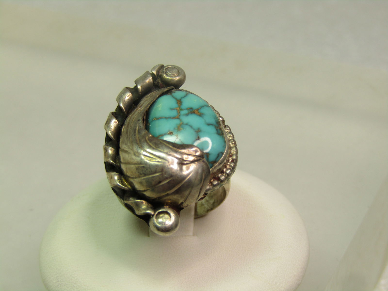 Vintage Sterling Southwestern Turquoise Ring, Feather Accents, Sz. 4.75, 1970's-1980's: Vintage Sterling Southwestern Turquoise Ring, Feather Accents, Sz. 4.75, 1970's-1980's is the estimated age. The turquoise is appx. 14mm by 10mm but given the setting it cannot be measured exactly. 