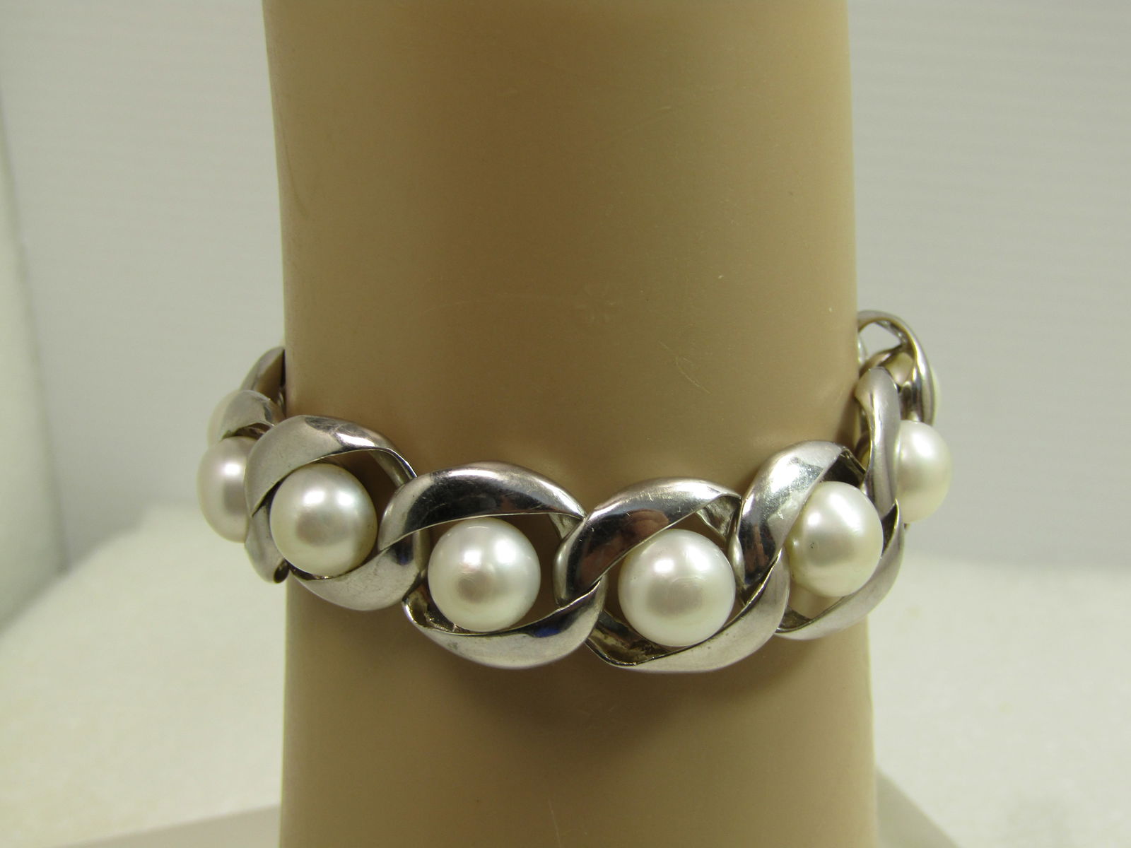 Vintage Sterling Cultured Pearl Bracelet, Signed KN, 7", 1980's-1990's: Vintage Sterling Cultured Pearl Bracelet, Signed KN, 7", 1980's-1990's. This has twelve stering links with curved sides and a diagonal opening where there is an appx. 8.5 mm round pearl in the center
