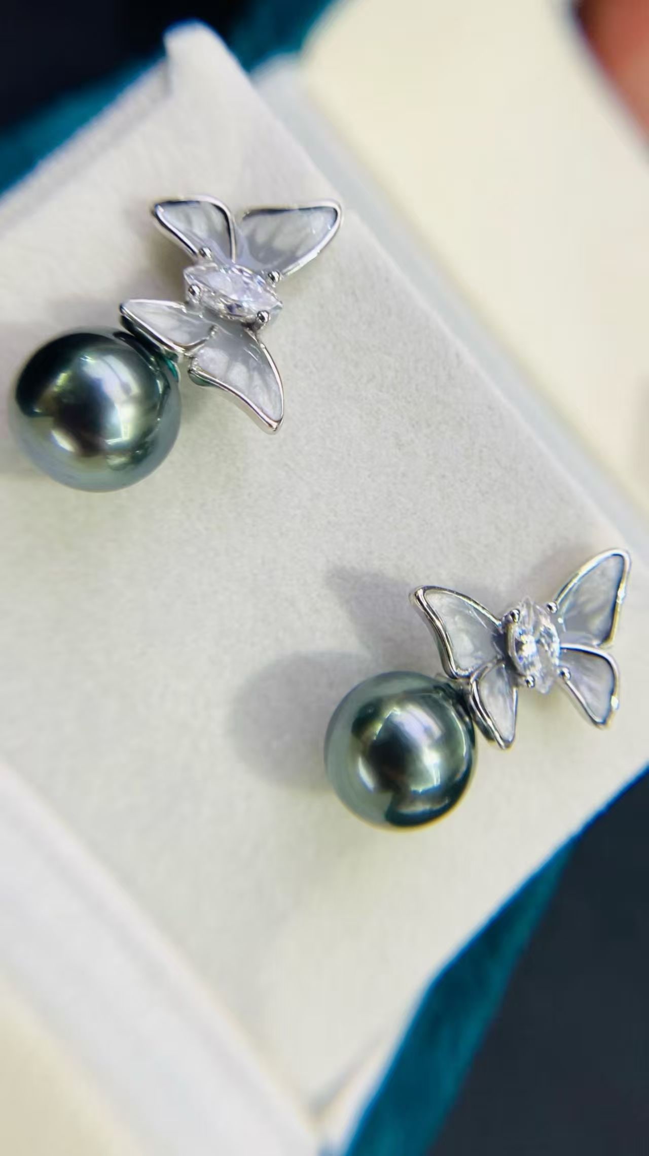 S925 pure silver butterfly bow pearl earrings ornament: Title: S925 pure silver butterfly bow pearl earrings ornament Description: These earrings feature 9-10mm Tahitian black pearls, renowned for their nearly flawless peacock blue color. The pearls emit