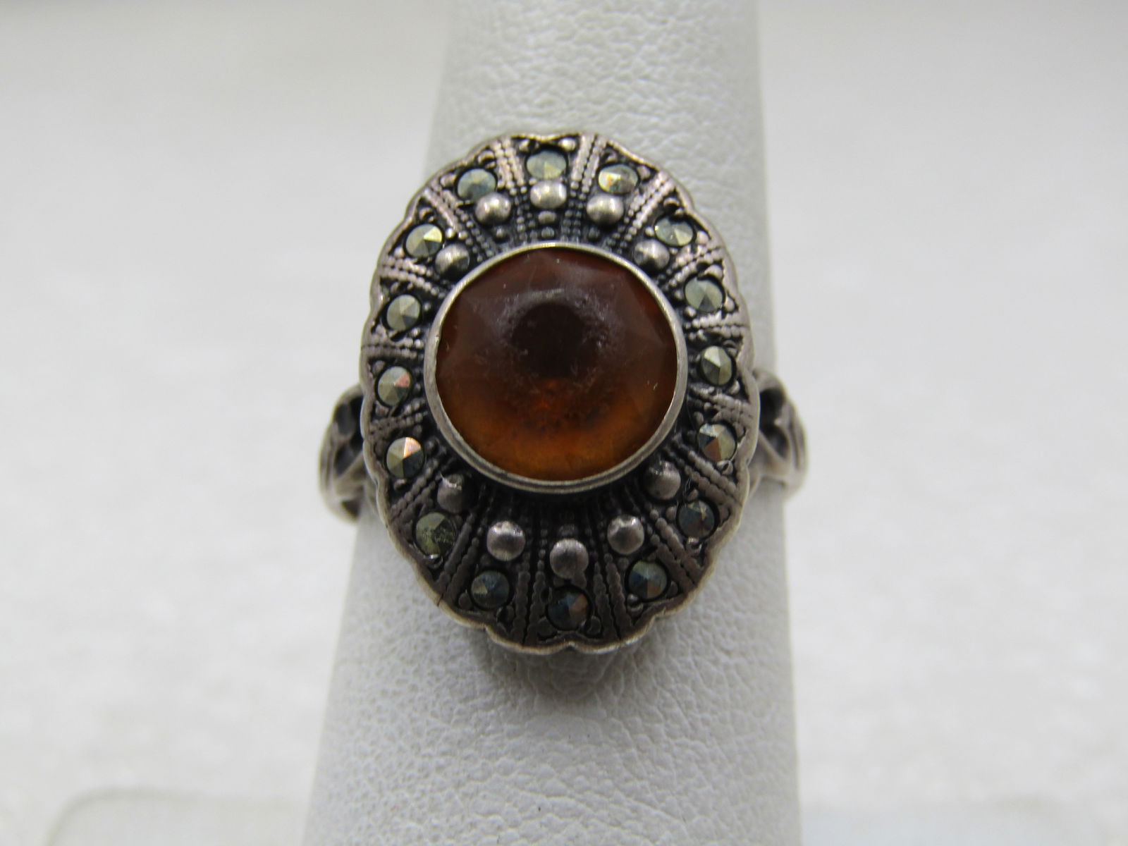 Vintage Sterling Marcasite Yellow Stone Ring, Sz. 7.5, Signed Uncas, Mid-Century: Vintage Sterling Marcasite Yellow Stone Ring, Sz. 7.5, Signed Uncas, Mid-Century. It has yellow glass round bezel-set stone et slightly higher in the center in a oval top to the ring with rows of marc