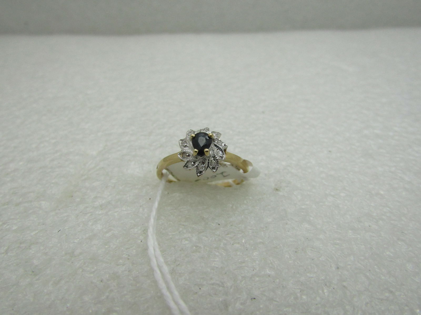 10kt Two-Tone Sapphire Diamond Ring, Sz. 6.5, 1.43 gr.: 10kt Two-Tone Sapphire Diamond Ring, Sz. 6.5, 1.43 gr. Signed pd. This has a center deep blue sapphire that is appx 3.8mm by 3.4mm pear-shaped stone that is set higher over a base of leaf-like white