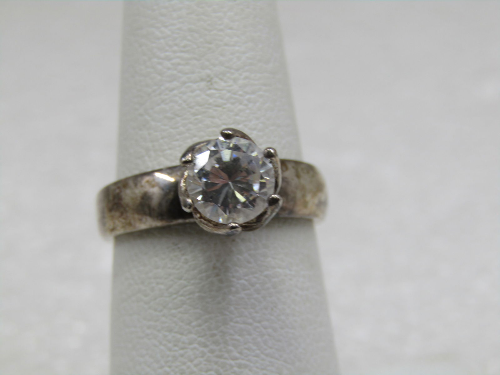 Sterling Clear CZ Engagement Ring, Sz. 7,: Sterling Clear CZ Engagement Ring, Sz. 7, marked .925, signed CW tested, weight is appx. 3.75 gr. Stone is appx. 7mm round. Wide band. The prongs that hold the stone wrap around the stone and are not