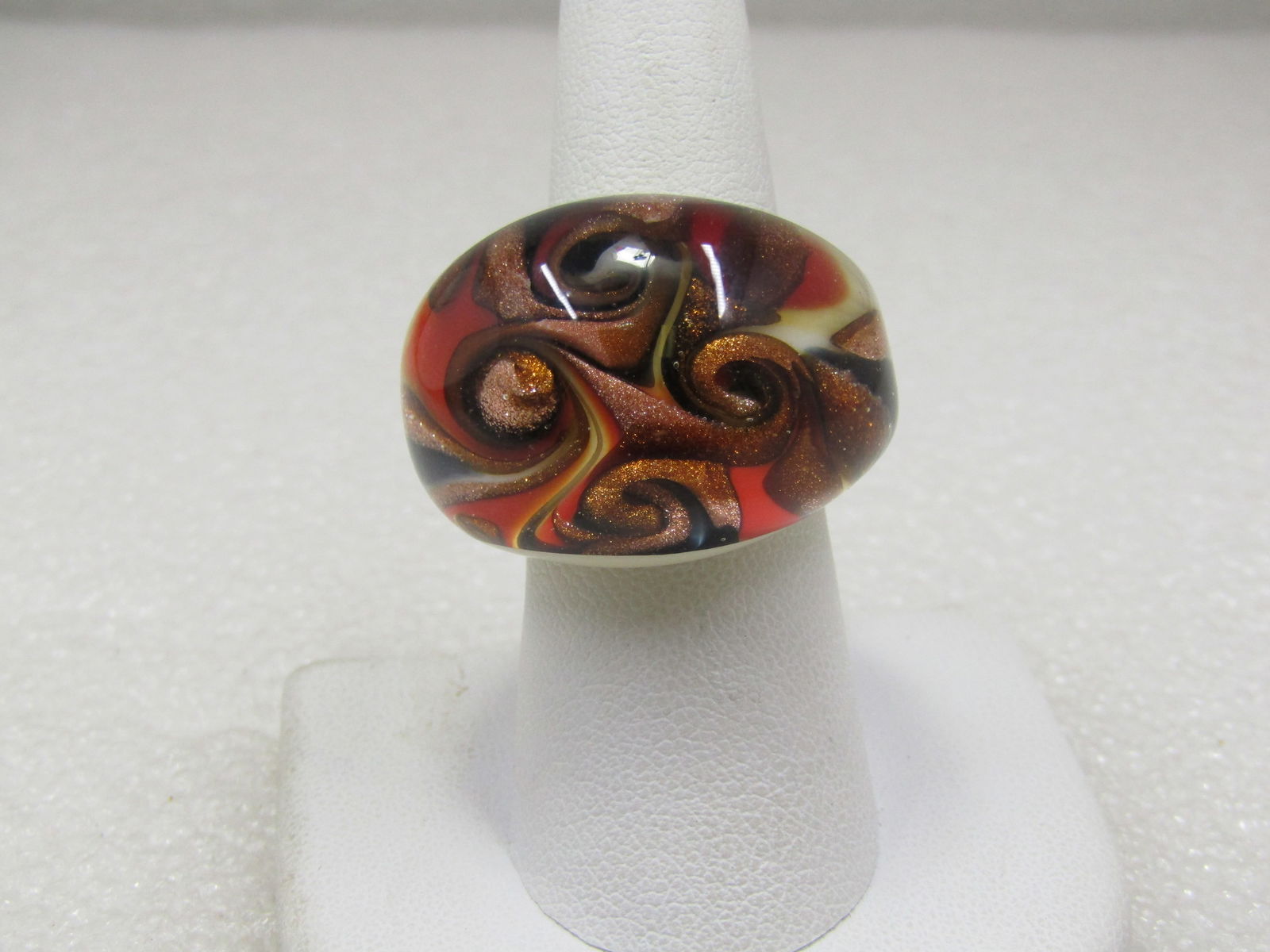 Swirled Glass Ring, Sz. 7, Domed, Murano Style: Swirled Glass Ring, Sz. 7, Domed, Murano Style. It is unnown if this is Murano but has the look - glitterly copper swirls mixed with black, almost look like rose blossoms in the ring with red and
