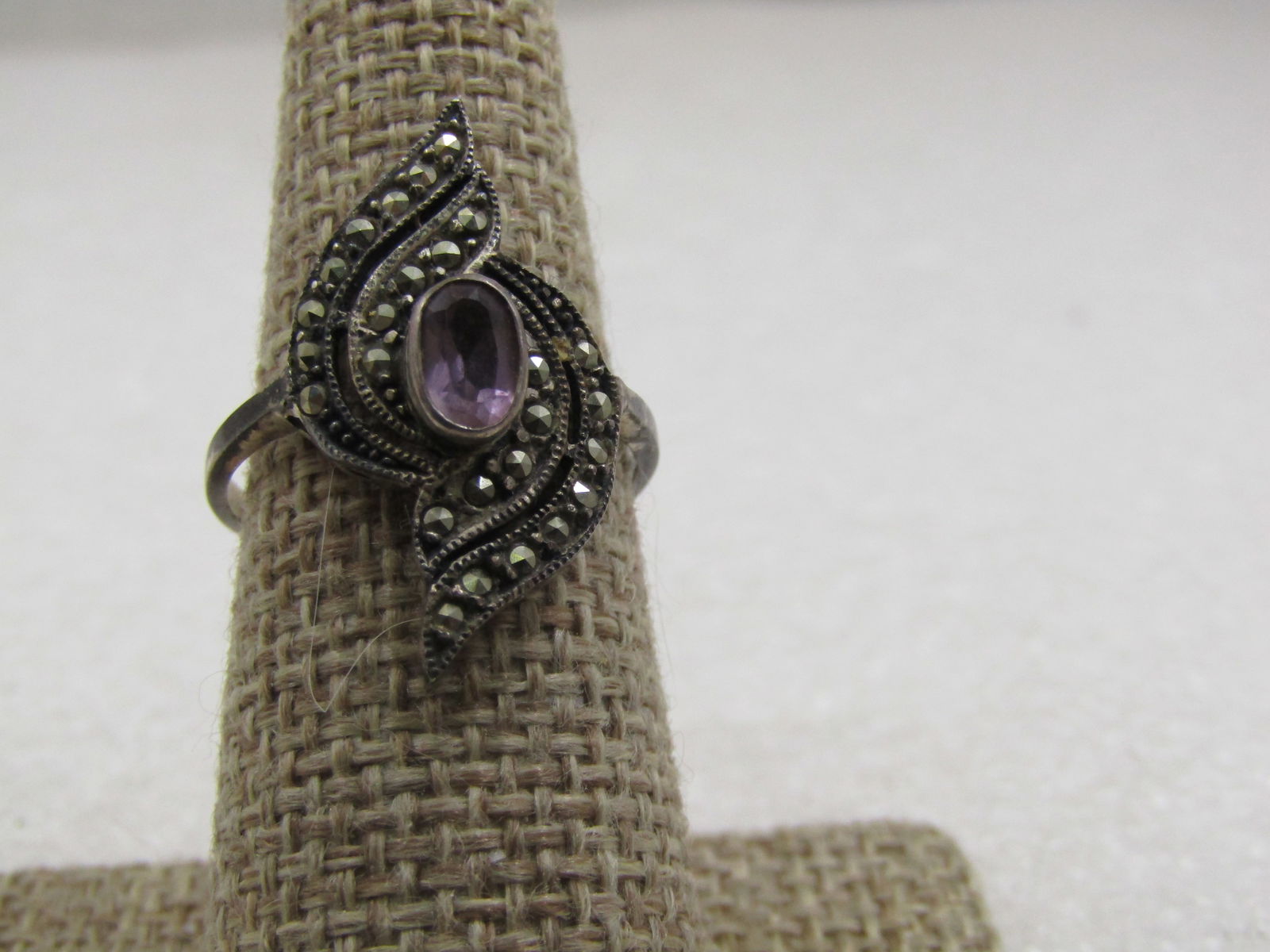 Vintage Sterling Marcasite Amethyst Bypass Ring , Sz. 8.25: Vintage Sterling Marcasite Amethyst Bypass Ring , Sz. 8.25. SIgned what looks lilke RAS. Marked .925 tested, weight is appx. 3.43 gr. The ring is 24.5mm down the finger with two curve rows of marcasit