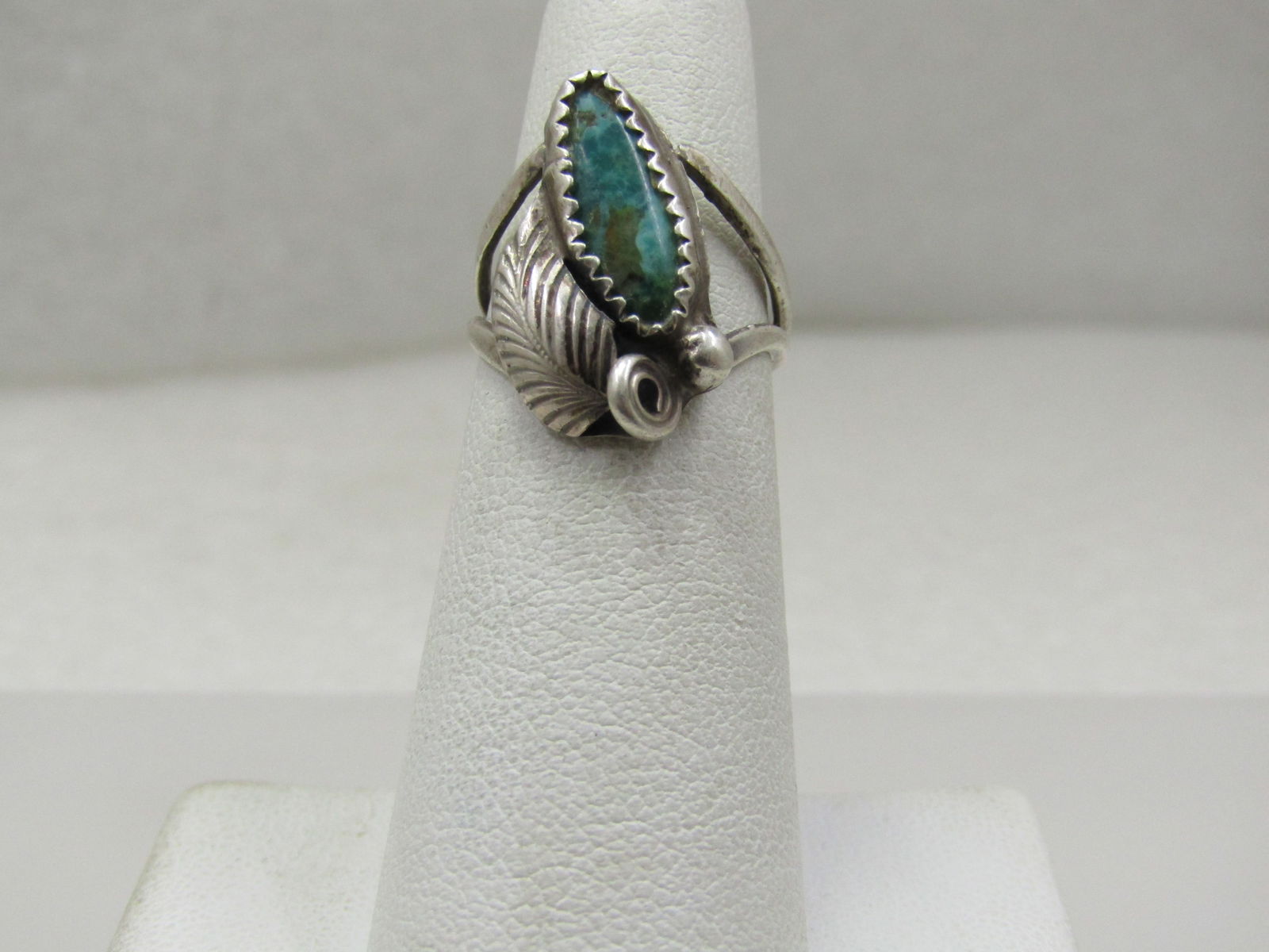 Vintage Sterling Southwestern Turquoise Feather Ring, Sz. 4.75: Vintage Sterling Southwestern Turquoise Feather Ring, Sz. 4.75. T his has an appx. 14.5mm by 6mm sawtooth bezel-set turquoise stone with a bead (raindrop) and feather accent. The top of the ring is