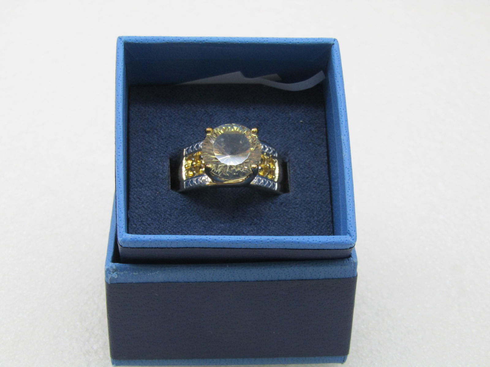 Sterling Yellow & Clear CZ Statement Ring, Sz. 10.25: Sterling Yellow & Clear CZ Statement Ring, Sz. 10.25. In original two-tone blue box. The main stone is an 11.5mm pale yellow cz with pave set clear stones in the band and daker yellow stones in a squa