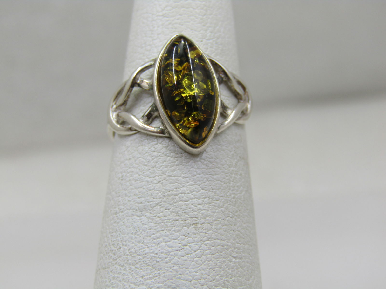 Vintage Sterling Amber Ring, Celtic, Sz. 4.5: Vintage Sterling Amber Ring, Celtic, Sz. 4.5. This has a celtic knot accent on each side of the cateye shaped amber cabochon stone that is appx. 12.5mm by 5.5mm. The cabochon is bezel-set and domed. I