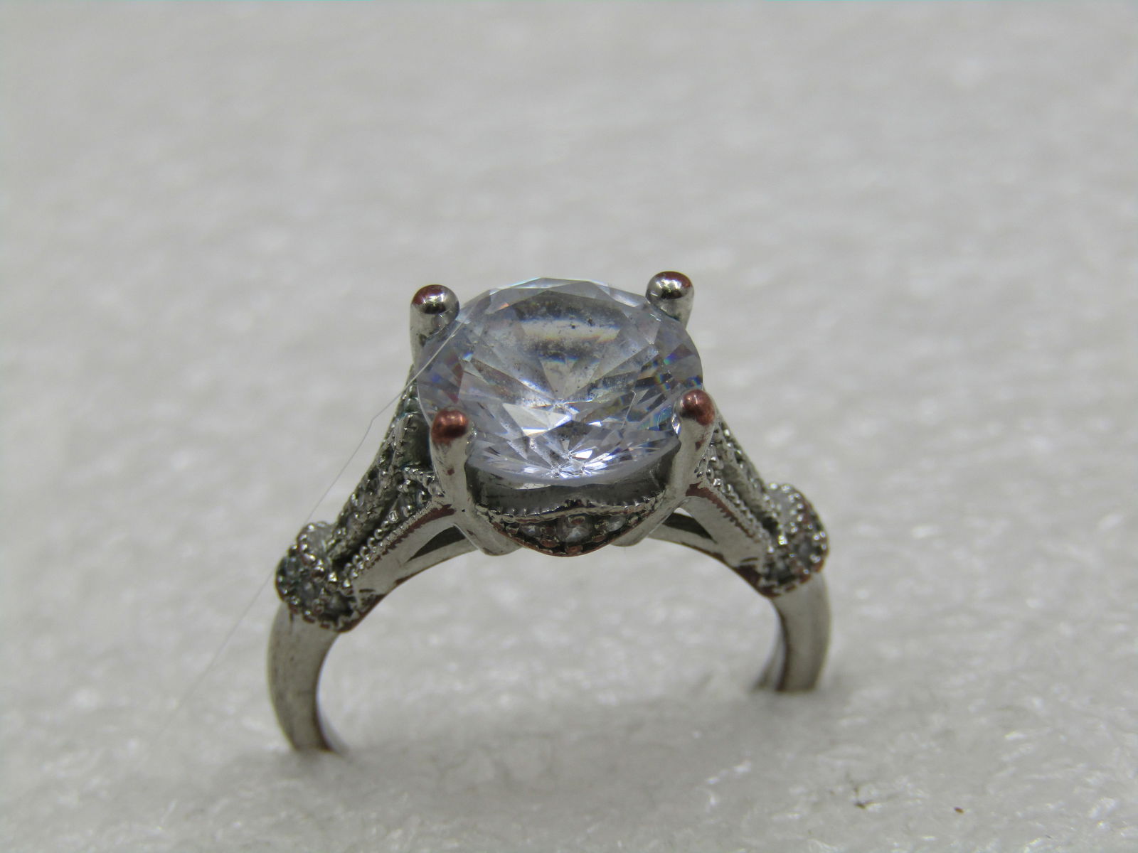 Vintage Silver Plated Clear Stone Engagement Ring, Sz. 7,: Vintage Silver Plated Clear Stone Engagement Ring, Sz. 7, The round stone is appx. 9.5mm round. Very nice desig with milgrain aceents. This is a costume ring. It is marked .925 but it s a thinly plate