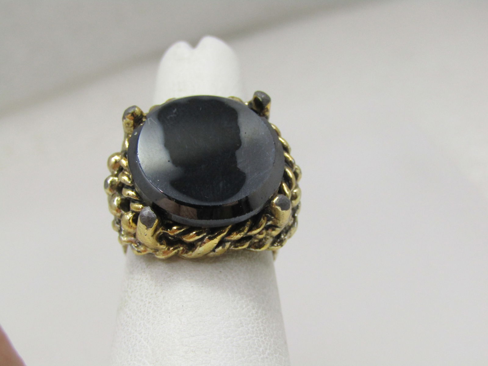 Vintage Black Glass Silhouette Cameo Ring, Adjustable , 1960's: Vintage Black Glass Silhouette Cameo Ring, Adjustable , 1960's. This has the look of hematite with the shilhouette of a cameo bust on the top. Sent in a chunky tiered gold tone rope accent setting and