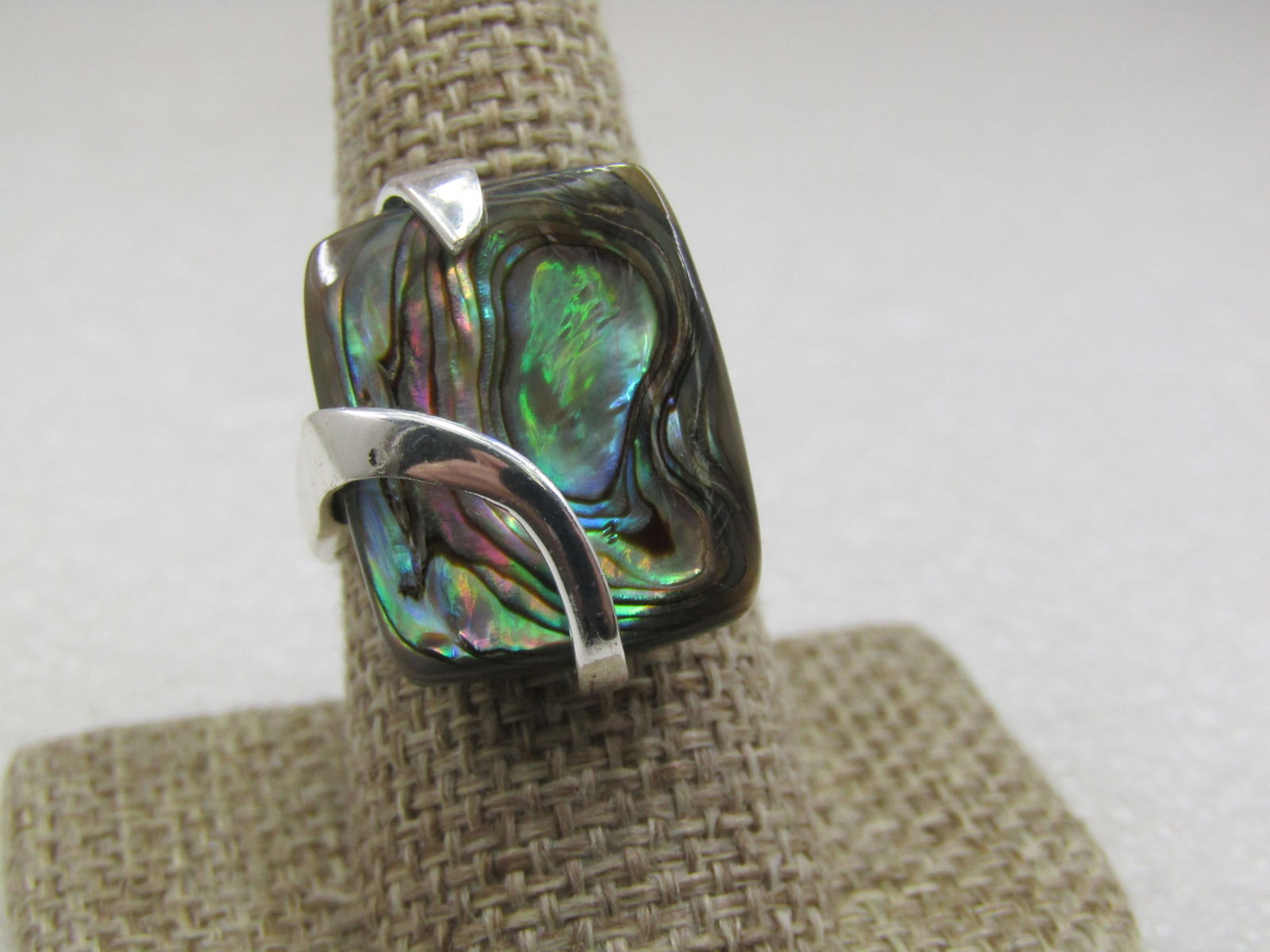 Sterling Silver Paua Shell Mod Wrapped Ring, Sz. 8.5: Sterling Silver Paua Shell Mod Wrapped Ring, Sz. 8.5, The shell is appx. 21.5mm down the finger and 17mm across and 3mm thick . The shell is mounted to a green flat base. The sterlnig varies in width