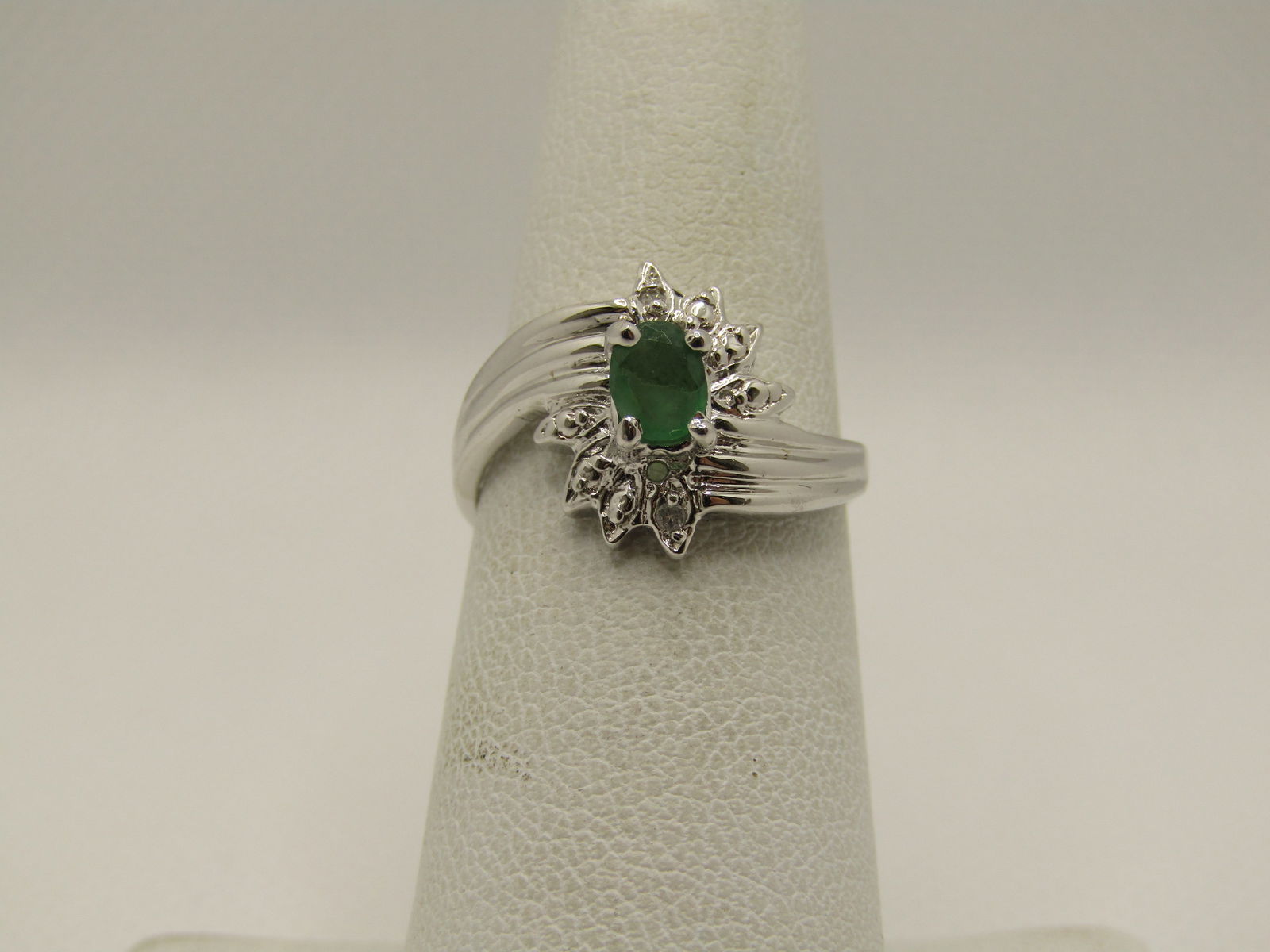 Silver Emerald Bypass Ring, Sz. 6, Contemporary Art Deco: Silver Emerald Bypass Ring, Sz. 6, Contemporary Art Deco. The stone tests as emerald and is appx. 5mm by 3.5mm oval. Prong-set and sits up on the art deco themed setting. The ring is appx. 3.5mm at th