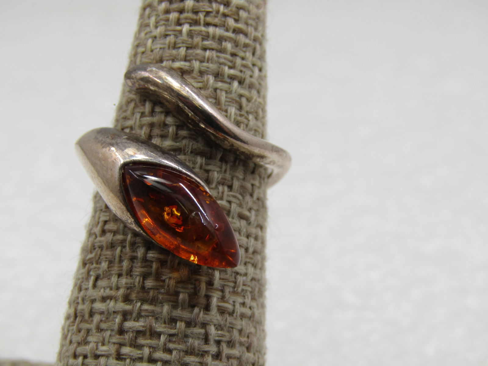 Vintage Sterling Amber Bypass Ring, Sz. 7: Vintage Sterling Amber Bypass Ring, Sz. 7. It has a marquise shaped amber cabochon that is appx. 12mm by 6mm set into the one end of the ring and is appx. 7.8mm at top on the widest point where the st