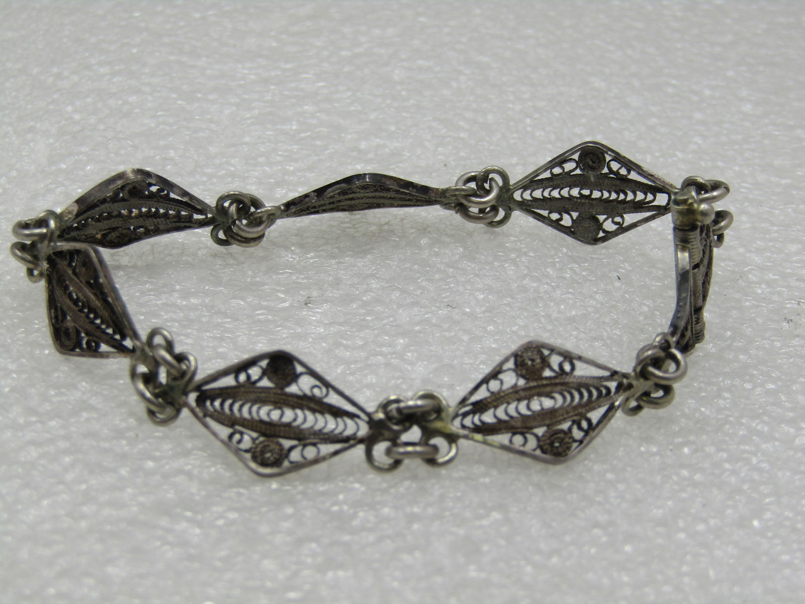 Vintage Sterling Filigree Bracelet, Pin Clasp, 7.25", 1940's: Vintage Sterling Filigree Bracelet, Pin Clasp, 7.25", 1940's. The bracelet is appx. 11.5mm wide with double jump ring connector links. The links are a curved filigree diamond shape with filigree cente
