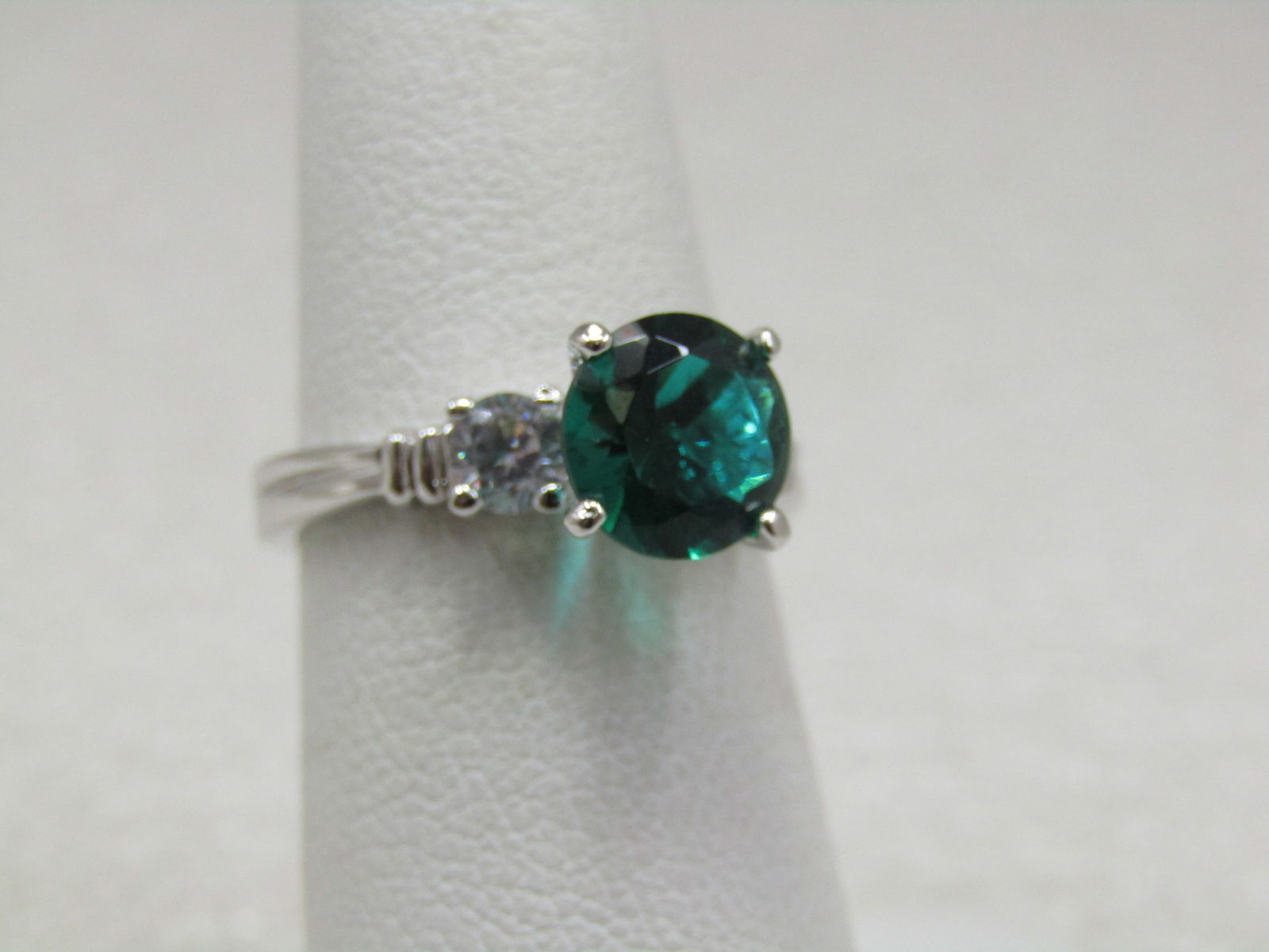 Sterling Plated Green & Clear Ring, Sz. 6.25, Engagement Style: Sterling Plated Green & Clear Ring, Sz. 6.25, Engagement Style. Very pretty setting with an emerald green crystal/glass stone that is round cut appx. 8mm round which sits high in the center with a 3.8