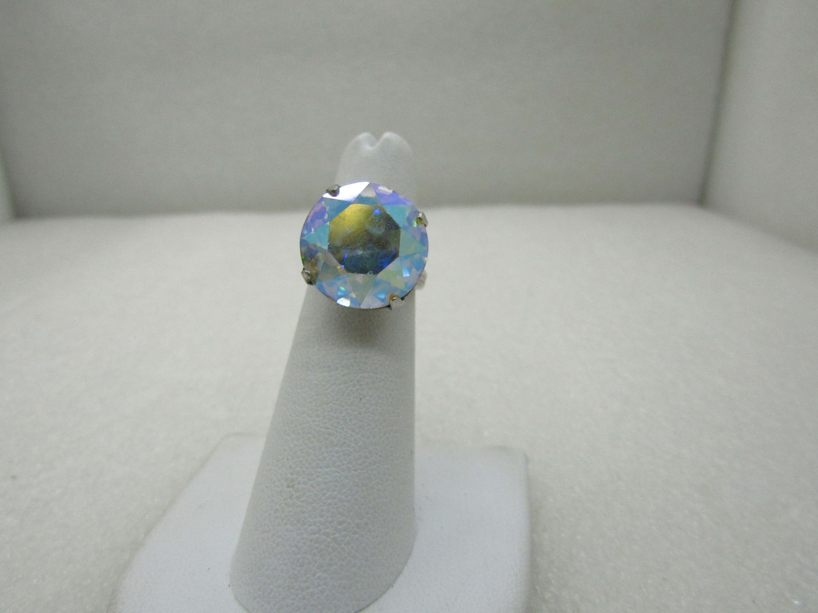 Vintage Sterling Silver AB Rhinestone Ring, Signed Uncas, Sz. 5.75: Vintage Sterling Silver AB Rhinestone Ring, 15.5mm , Uncas, Large round faceted aurora borealis 15.5mm stone, prong set with an art deco themed setting. Size. 5.75. Very nice ring, great as a cocktail
