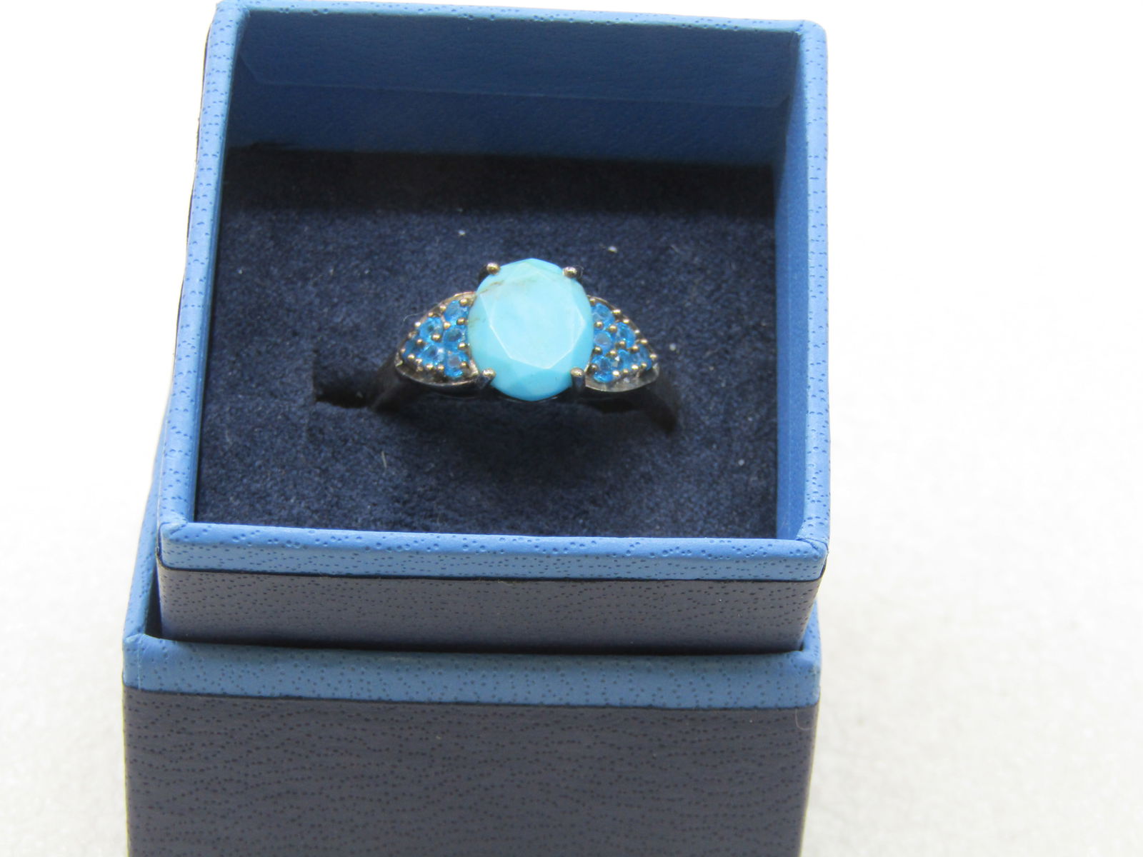 Sterling Turquoise & Teal Rhinestone Ring, Sz. 10.5: Sterling Turquoise & Teal Rhinestone Ring, Sz. 10.5. This has a center turquoise stone with faceted edges that is appx. 10.5mm by 8.5mm held by four prongs with pave-set teal rhinestones set in