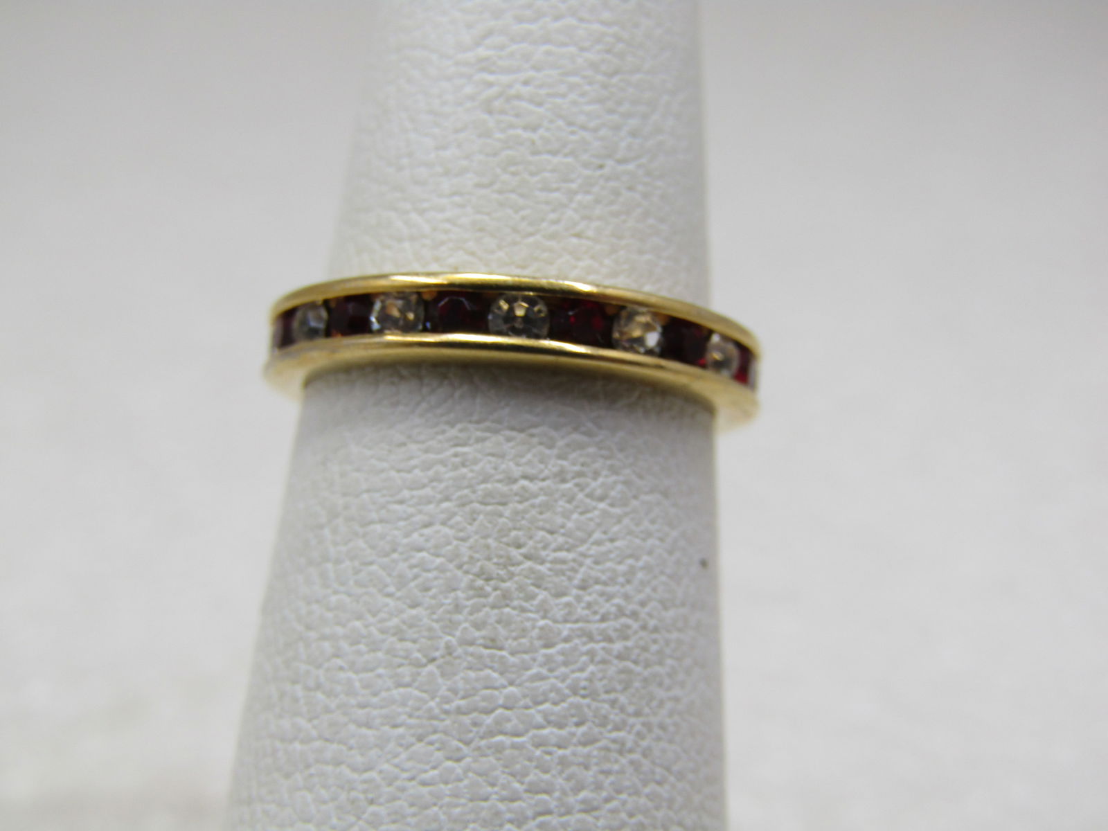 10kt Plated Red/Clear CZ Ring, Eternity Band, Sz. 4: 10kt Plated Red/Clear CZ Ring, Eternity Band, Sz. 4. 3mm round with alternating red and clear czs. They go around the entire ring. The ring is not marked or signed. It tests as 10kt and is either G.F.