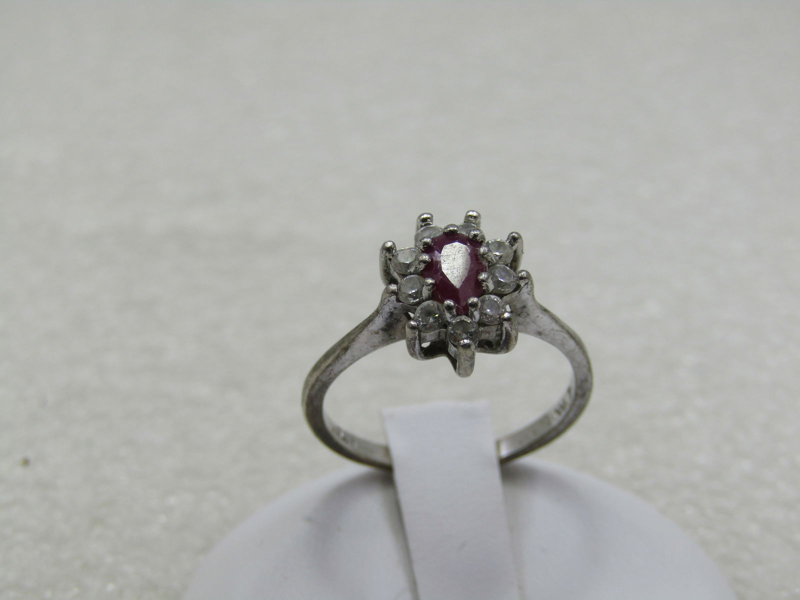 Vintage Sterling Ruby Halo Rhinestone Ring, Sz. 7.5, Signed: Vintage Sterling Ruby Rhinestone Ring, Sz. 7.5, Signed NV. Pear Shaped 5mm by 3.5mm stone that tests as ruby, likely lab created or a lesser stone given that it is paired with rhinestones. Still very