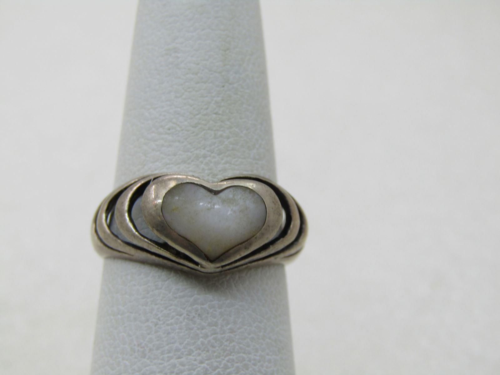 Vintage Sterling MOP Heart Ring, Sz. 6: Vintage Sterling MOP Heart Ring, Sz. 6, 3.11 gr. Center inlaid mother-of-pearl heart with what looks like stepped heart frames going down the finger. Open design. The ring is appx. 9mm down the top of