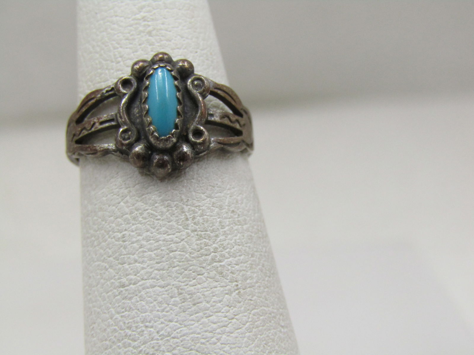 Vintage Sterling Southwestern Turquoise Ring, Sz 4.5, 1960's-1970's: Vintage Sterling Southwestern Turquoise Ring, Sz 4.5, 1960's-1970's. There is a bezel-set turquoise stone that is appx. 7mm by 3.5mm in the center with a scrolled and beaded frame around it. The