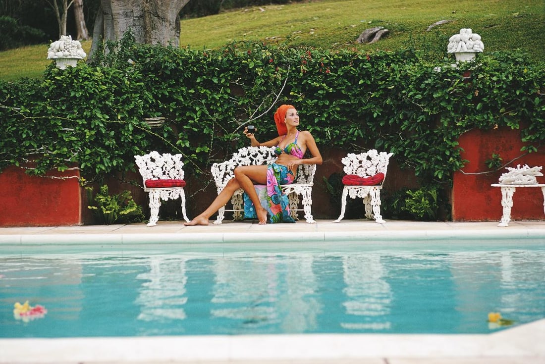 Slim Aarons Limited Estate Edition Lounging in Bermuda: 1970 (Printed Later): Title: Slim Aarons Limited Estate Edition Lounging in Bermuda: 1970 (Printed Later) Description: Slim Aarons Limited Estate Edition Lounging in Bermuda Jill Council relaxes with a drink by a swimming
