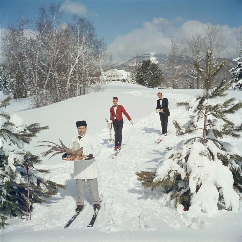 Skiing Waiters' Slim Aarons Limited Estate Edition: 1960 (printed later): Title: Skiing Waiters' Slim Aarons Limited Estate Edition: 1960 (printed later) Description: Slim Aarons 'Skiing Waiters' Three skiing waiters on a ski slope, with the man in the foreground carrying