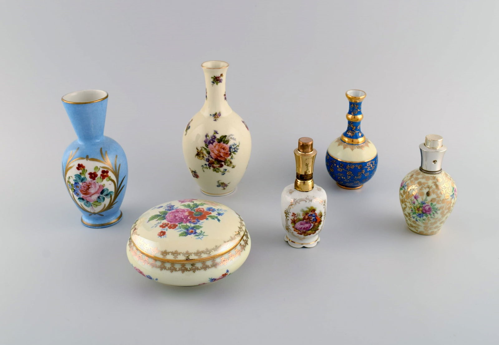 Limoges, France. Two perfume bottles, three vases and lidded box in hand-painted porcelain. Flowers: Title: Limoges, France. Two perfume bottles, three vases and lidded box in hand-painted porcelain. Flowers and gold decoration. 1930s / 40s. Description: Limoges, France. Two perfume bottles, three