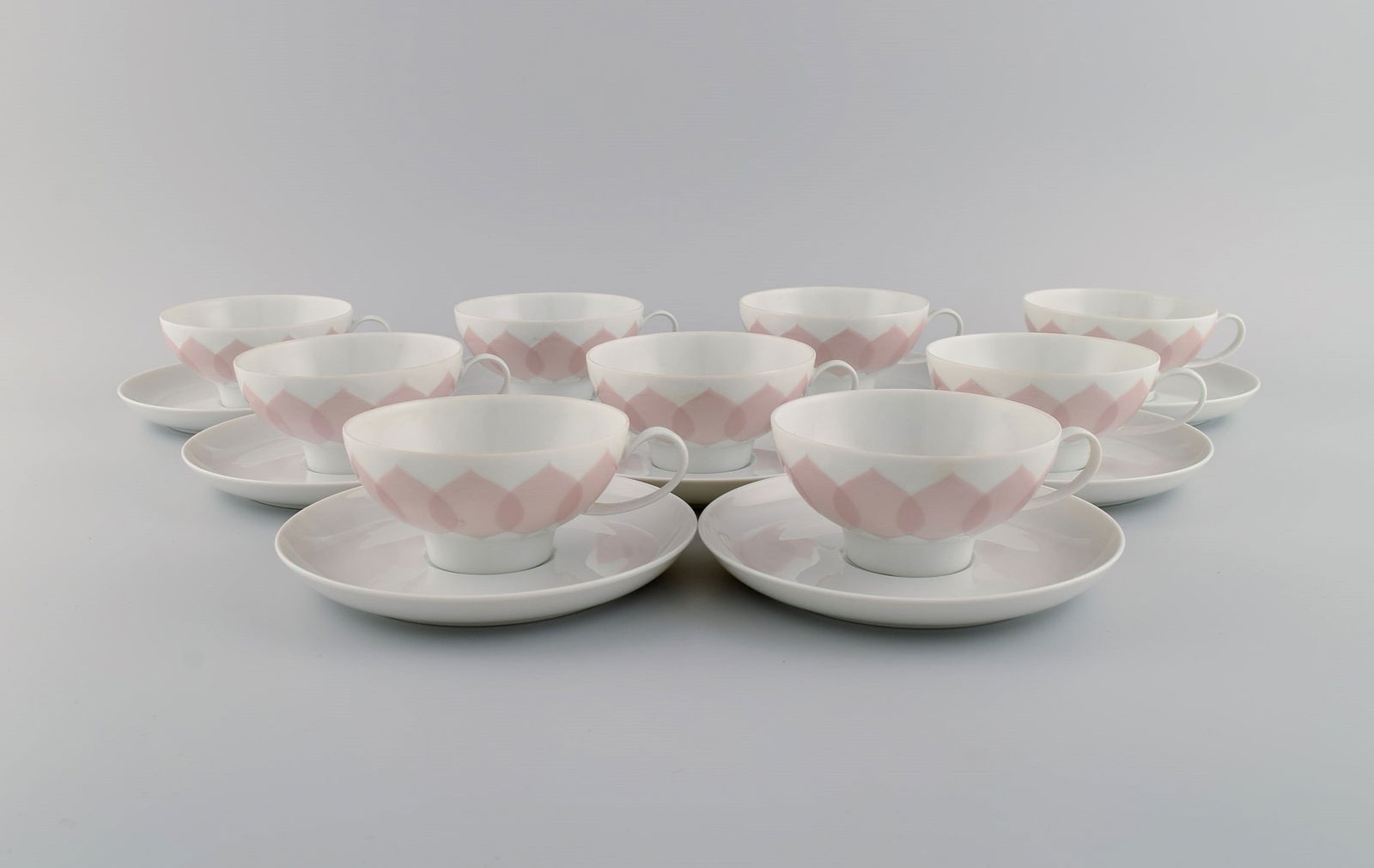 Bjørn Wiinblad for Rosenthal. Lotus porcelain service. 9 teacups with saucers decorated with: Title: Bjørn Wiinblad for Rosenthal. Lotus porcelain service. 9 teacups with saucers decorated with pink lotus leaves. 1980s. Description: Bjørn Wiinblad for Rosenthal. Lotus porcelain
