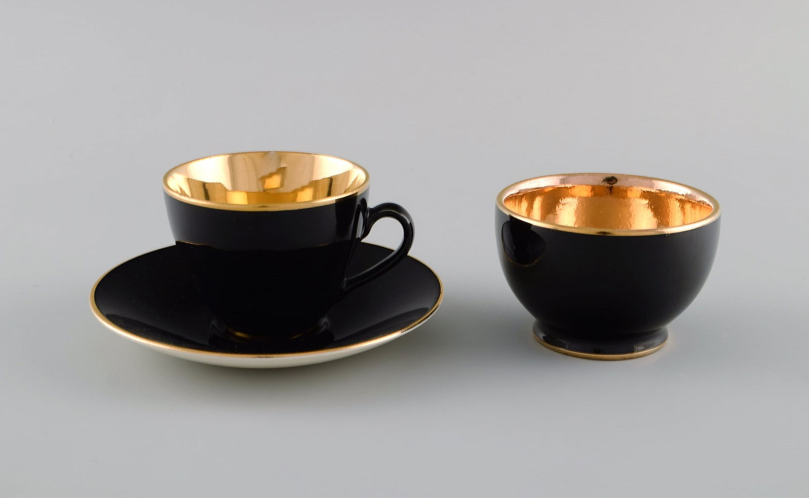 Royal Copenhagen / Aluminia Confetti mocha cup with saucer and sugar bowl in black glazed faience: Title: Royal Copenhagen / Aluminia Confetti mocha cup with saucer and sugar bowl in black glazed faience with interior gold. Mid-20th century. Description: Royal Copenhagen / Aluminia Confetti mocha c
