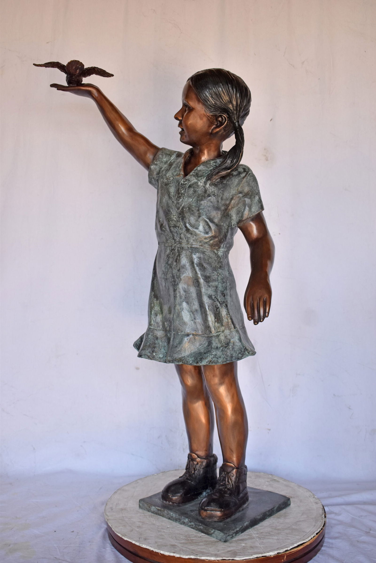 Young Girl Holding a Bird Outside at The Park - Size: 21"L x 11"W x 49"H. - 3