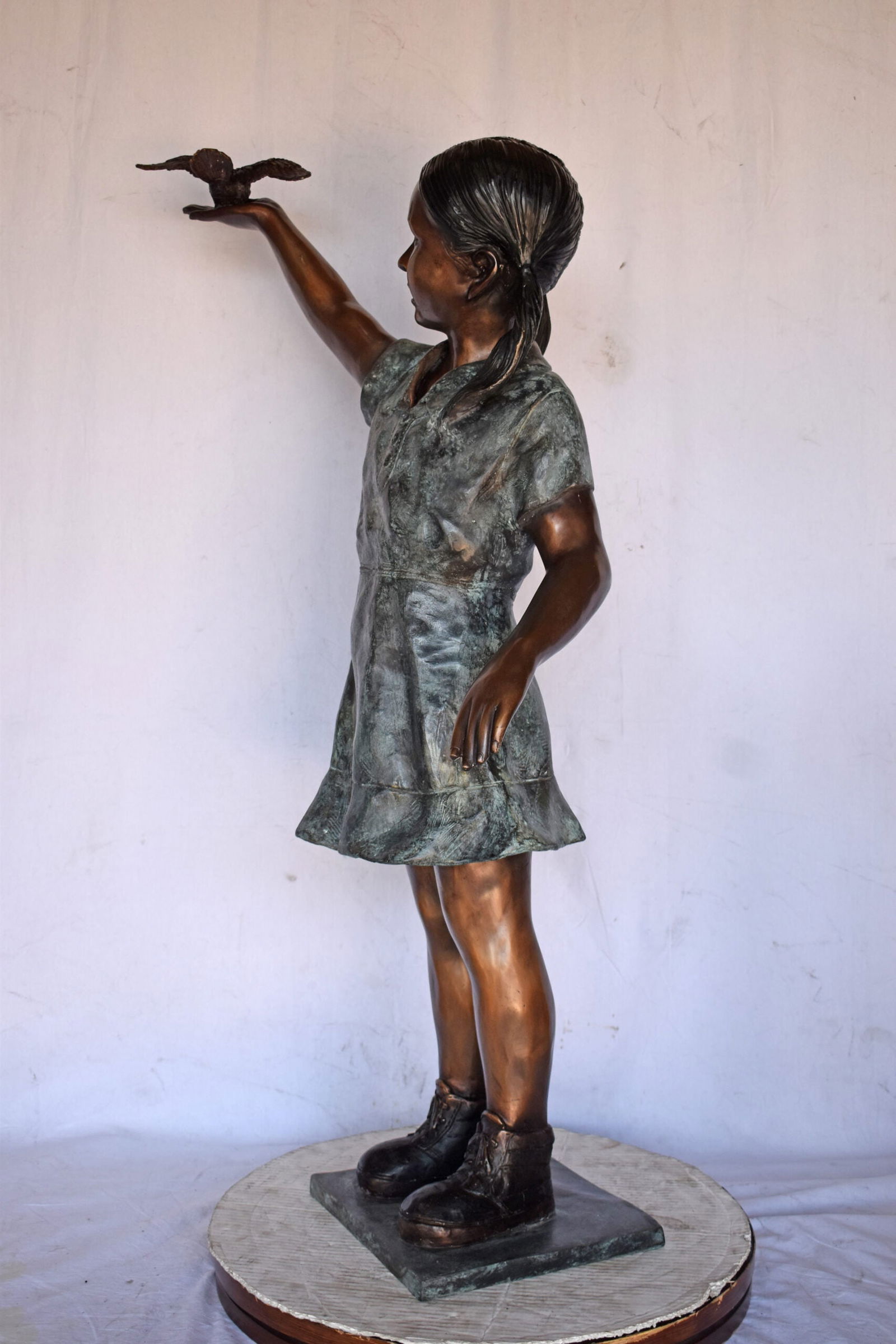 Young Girl Holding a Bird Outside at The Park - Size: 21"L x 11"W x 49"H. - 4