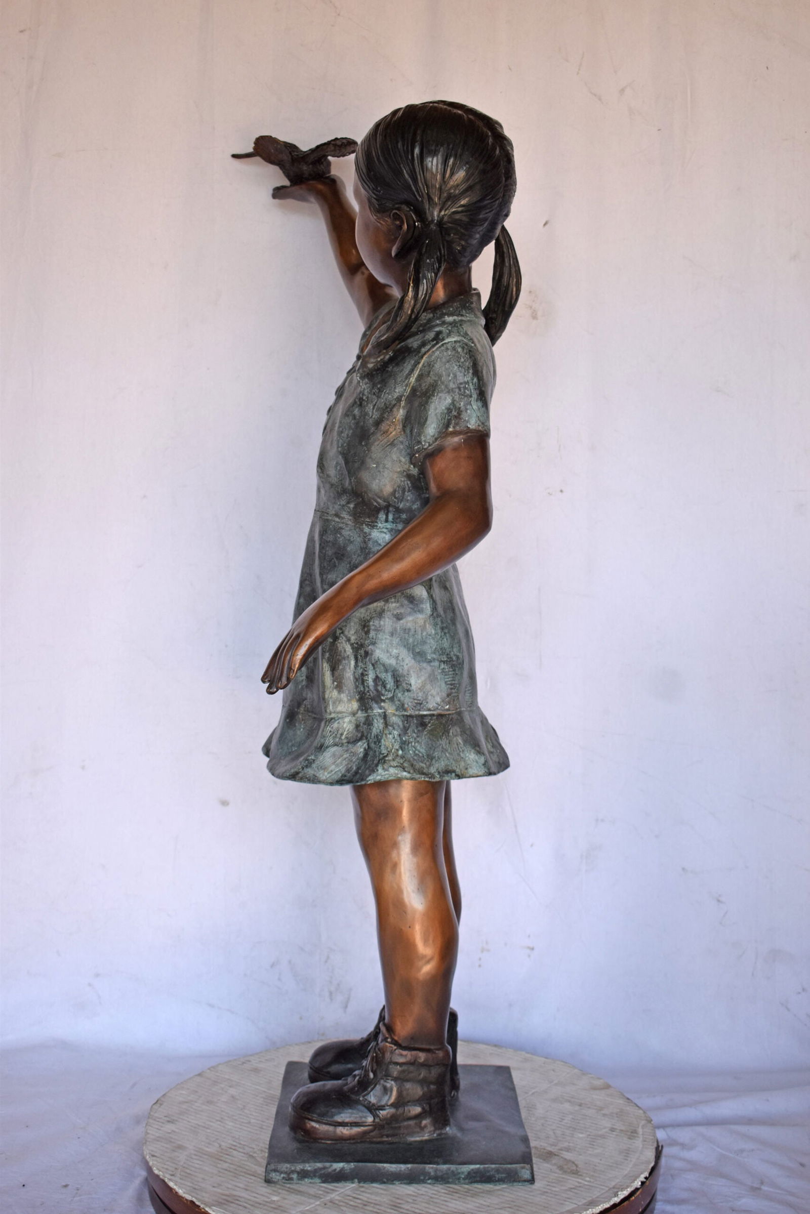 Young Girl Holding a Bird Outside at The Park - Size: 21"L x 11"W x 49"H. - 5
