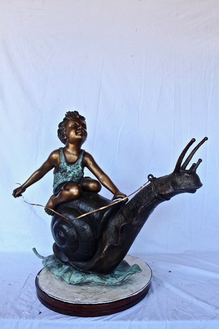 Happy boy riding a snail bronze statue fountain - Size: 42"L x 14"W x 34"H. - 3