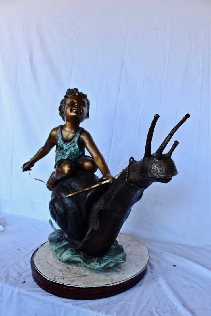 Happy boy riding a snail bronze statue fountain - Size: 42"L x 14"W x 34"H. - 5
