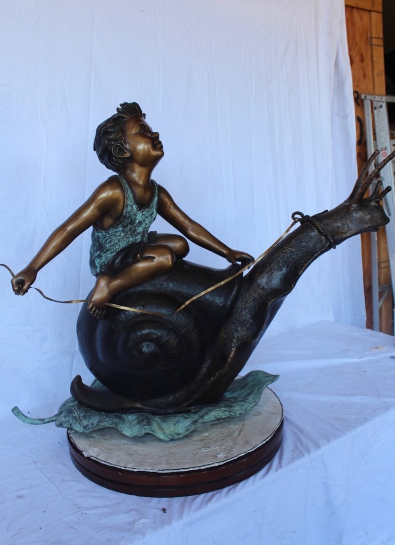Happy boy riding a snail bronze statue fountain - Size: 42"L x 14"W x 34"H. - 6