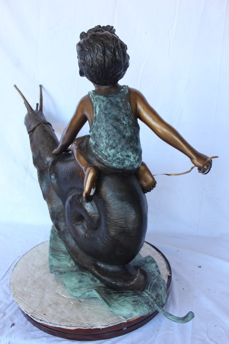 Happy boy riding a snail bronze statue fountain - Size: 42"L x 14"W x 34"H. - 9